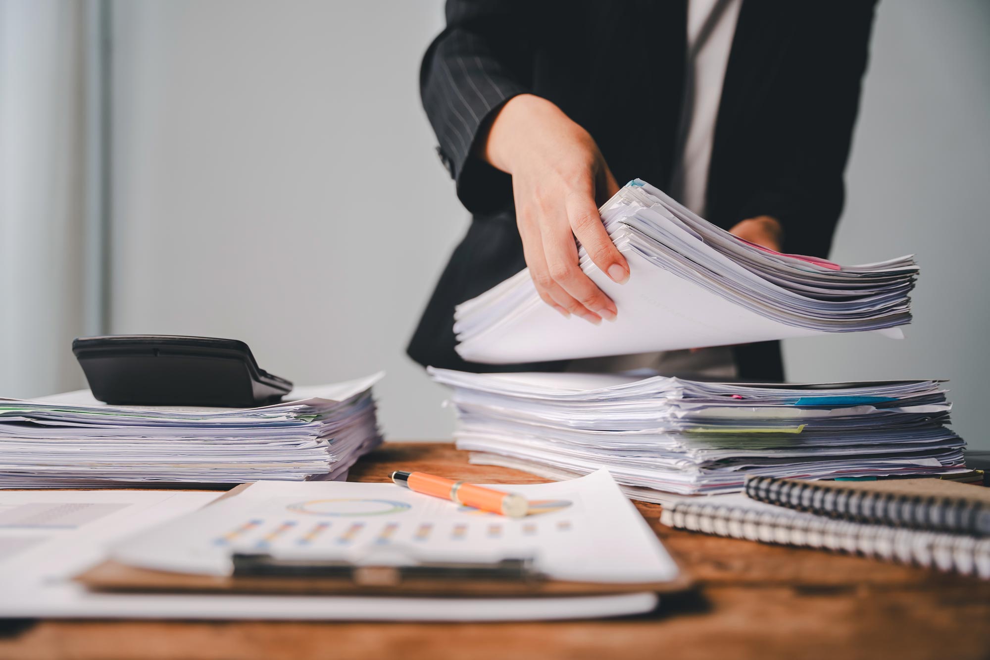 Redovisningskonsult staplar upp en hög med bokföringspapper