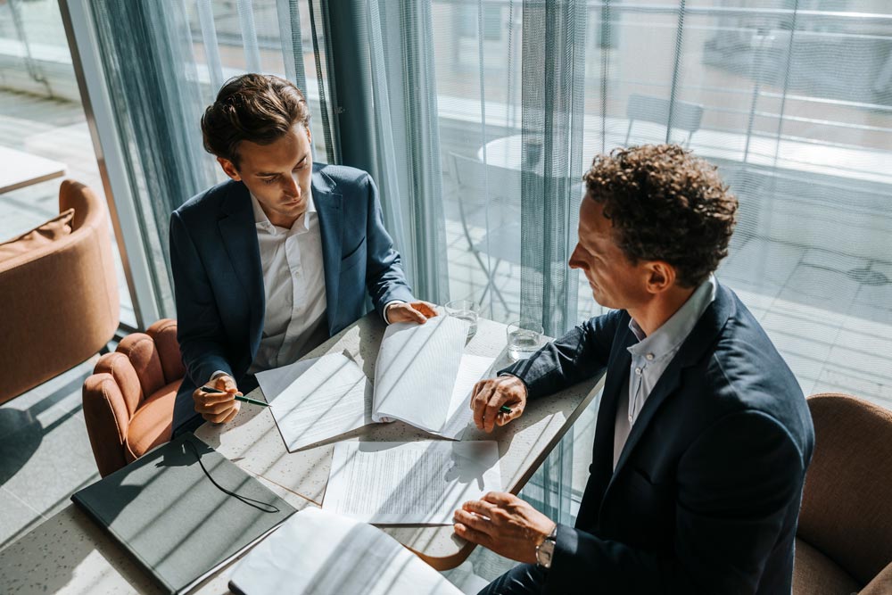 Två personer granskar papper under ett möte